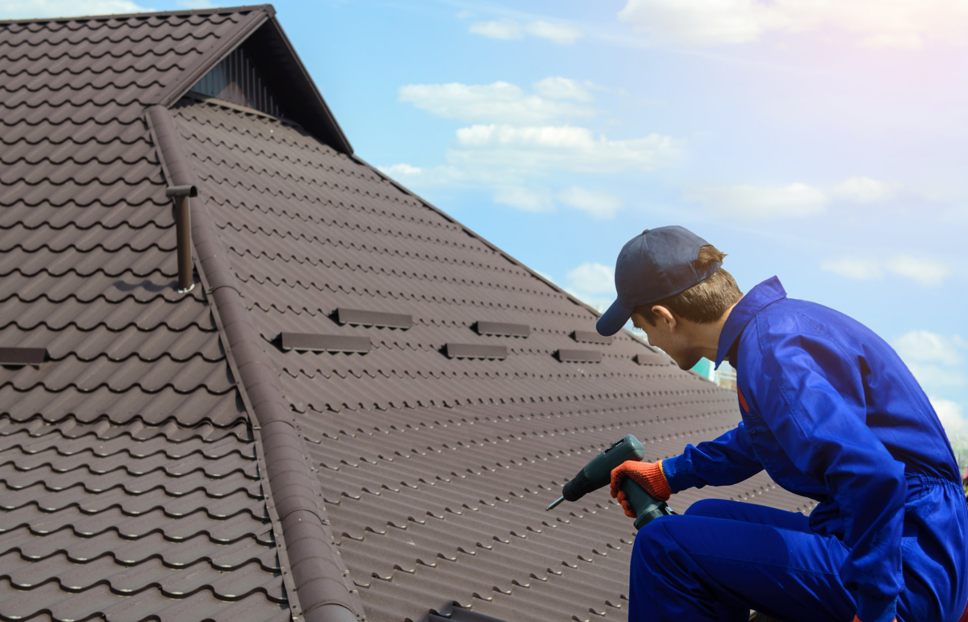 H4 Roofing & Construction crew member fastening metal roof tiles on a Dayton, Ohio home